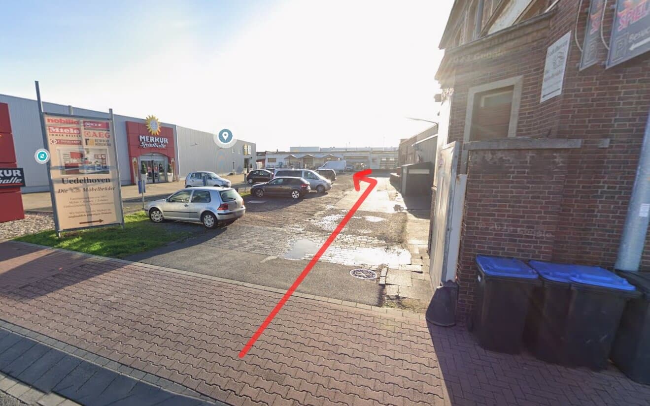 Anfahrt zum CANNEU Social Club: Blick vom Parkplatz Richtung Eingang der Mega-Fun-Spielhalle in Euskirchen mit rotem Pfeil